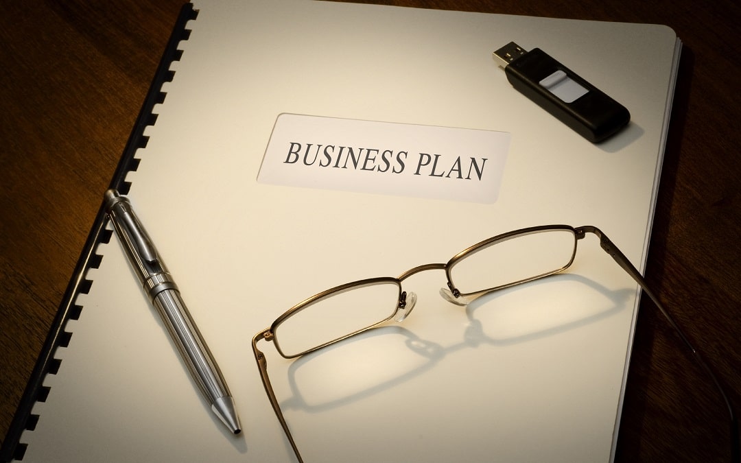 Business Plan on a desk with a pen